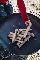 Wood being stacked in a fire bowl