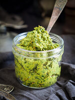 Homemade vegan spinach and sun-dried-tomato pesto in a jar