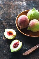 Green peaches in a wooden bowl and next to it