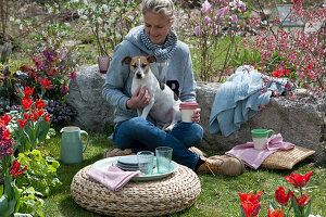 Frau mit Hund Zula genießt den Frühlingsgarten