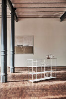 Delicate, modern shelves in old factory with metal pillars