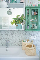 Baskets on sink below shelves and wall-mounted cabinet in bathroom