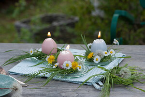 Kleine Tischdeko mit Osterkerzen in Blütenkränzchen