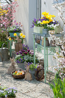 Easter terrace with tulips, daffodils, flowering perennials, and Easter decoration