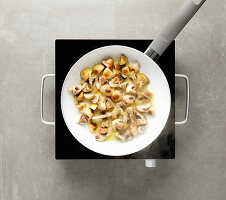 Mushrooms being fried in a pan