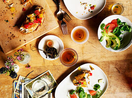 Brunch scene of smoked fish on bread with citrus, cress, avocado salad and loose-leaf tea