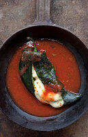 Chile Relleno with red salsa in cast iron skillet