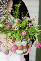 Bouquet of tulips, shepherd's purse and Australian waxflowers in wire basket with eggs