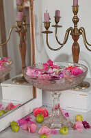 Pale pink and deep pink flowers floating in glass confectionary dish