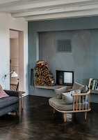 A cosy chair on a concrete floor in front of a fireplace in a blue wall