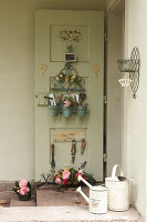 Haustüre mit Ordnungshelfer und Utensilien, Korb mit Rosenblüten