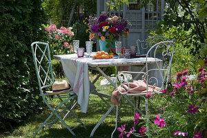 Colourful summer bouquet of roses, flame flowers, oregano, yarrow and chamomile as a table decoration