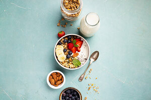 Oat granola with fresh berries, banana, yogurt, chia seeds and mint leaves