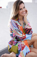 A young woman wearing a brightly patterned summer dress