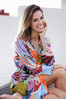 A young woman wearing a brightly patterned summer dress