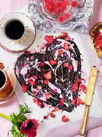 Schokoladenherz mit getrockneten roten Beeren, Geleebonbons und Kaffee zum Valentinstag