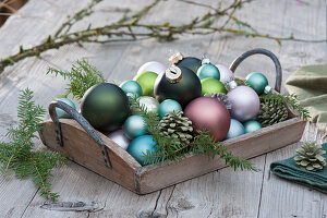 Tablett mit Christbaumkugeln und Zapfen als schlichte Dekoidee