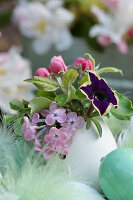 Mini-bouquet of lilac blossom, apple blossom, and petunias in a duck egg as a vase