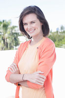 A young woman wearing an apricot top and cardigan