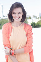 A young woman wearing an apricot top and cardigan