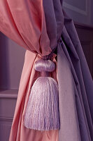 Pink and purple curtains with tasselled tie-back