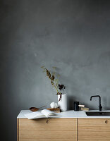 Open book on minimalist kitchen counter against grey wall