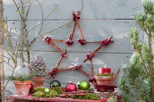 Star made of cinnamon sticks with balls, cones and candles as a Christmas decoration