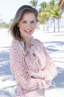 A long-haired woman wearing a floral-patterned blouse