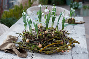 Snowdrops in a wreath of lichen-covered twigs, birch, willow and grass, decorated with onions