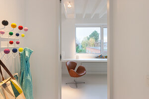 Modern reading area with brown leather armchair and colorful wardrobe hooks