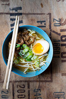 Ramen soup with beef, spring onions, sprouts and an egg