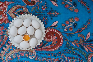 Weisse Eier auf blauer Tischdecke mit floralem Muster