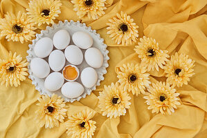 White eggs and yellow gerbera flowers