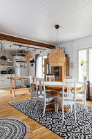 Dining table and country-house kitchen in open-plan interior in Bohemian style