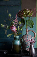 Vases of hydrangeas, protea, astilbes and sea holly 'Supernova'