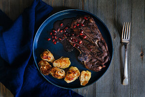 Grilled lamb chop with red pomegranate sauce and pan roasted brussel sprouts topped with bacon and cashews