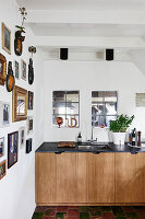 Collection of pictures on white wall and view of kitchen counter