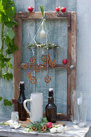 Biergarten-Deko für daheim : alter Fensterrahmen mit Bierflaschen, Krügen, Gläsern, Kranz mit Brezeln, Radieschen und Zwiebel