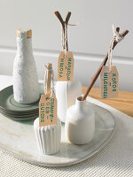 Small vases with branches on labels with recipe names