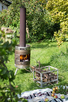 Selbstgemachter Ofen aus einem Metallfass im Garten