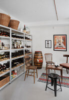 Various old chairs next to shelves holding bottles of spirits and wines