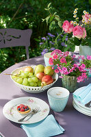 Fruit bowl and flower arrangement on table set for coffee