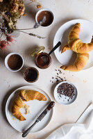 Frühstück mit Croissants, Kakao, Nussaufstrich und Kakaonibs