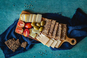 Käseplatte mit Oliven, Tomaten und Knäckebrot