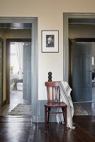 Black-and-white photo on wall above chair placed between two door frames