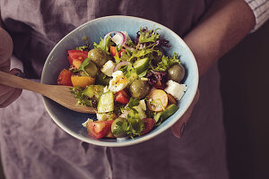 A woman eating Greek salad with feta