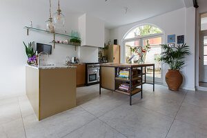 Island counter in open-plan kitchen with large floor tiles