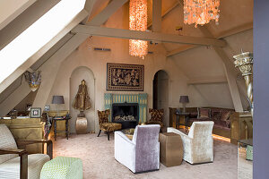 Seating area with fireplace, chandelier and artworks in attic room