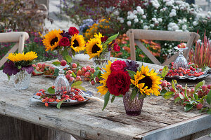 Herbstliche Tischdeko mit Zieräpfeln, Sonnenblumen und Rosen