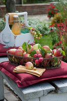 Basket with freshly picked apples, bottle with apple juice and glasses